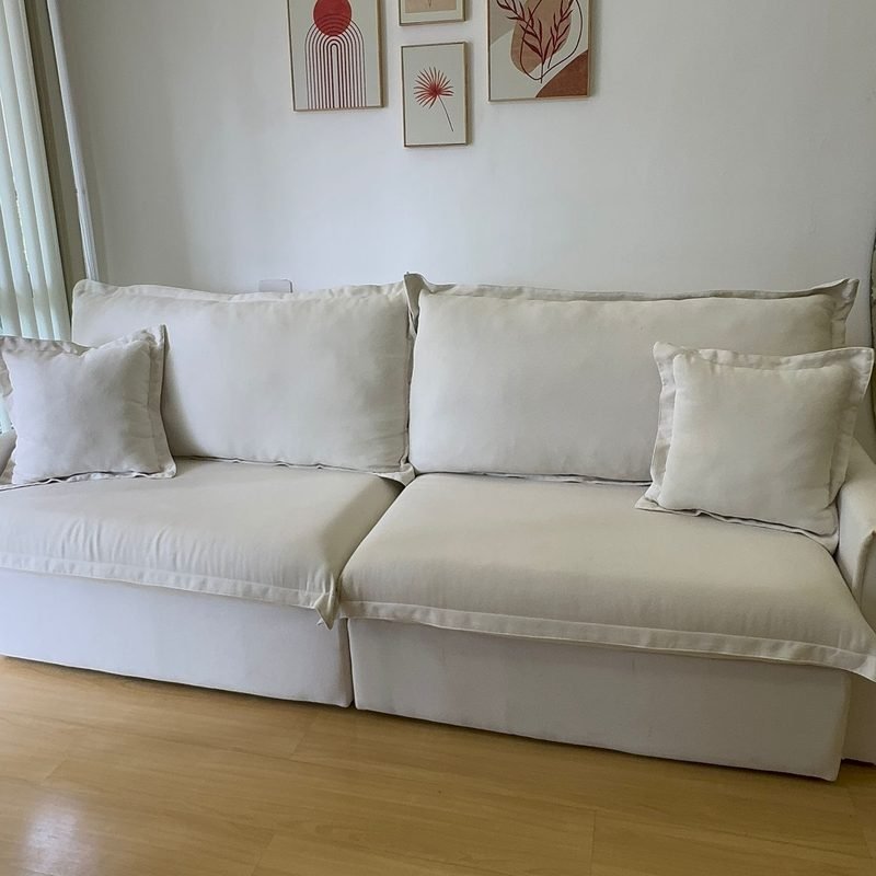 Sofá Cama Ágata visto de frente, fechado, numa sala de apartamento